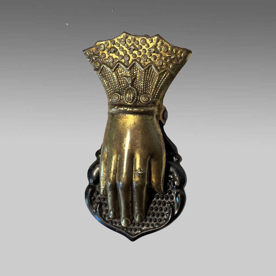 Gilt brass paper clip in the form of a gloved hand.